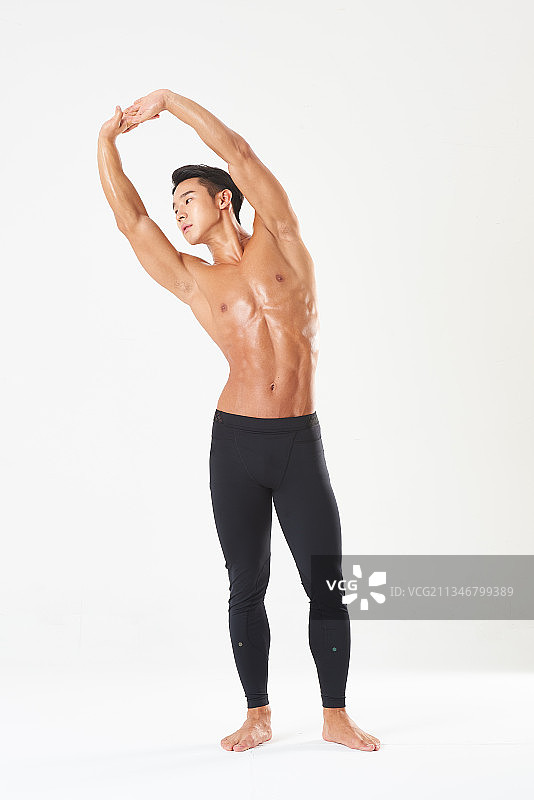 健壮的男人在工作室伸展双臂图片素材