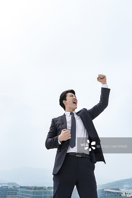 商务人士欢呼雀跃地站在阳台上图片素材