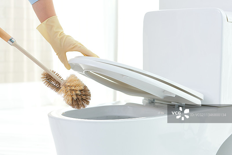 戴橡胶手套用刷子清洁马桶图片素材