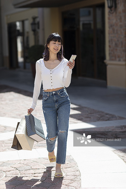 快乐的年轻女子逛街购物图片素材