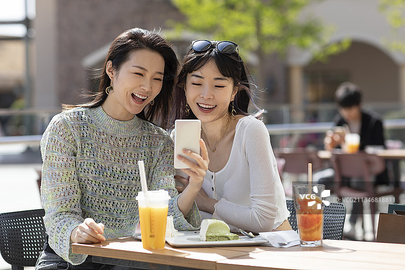 闺蜜俩在露天咖啡馆聊天图片素材