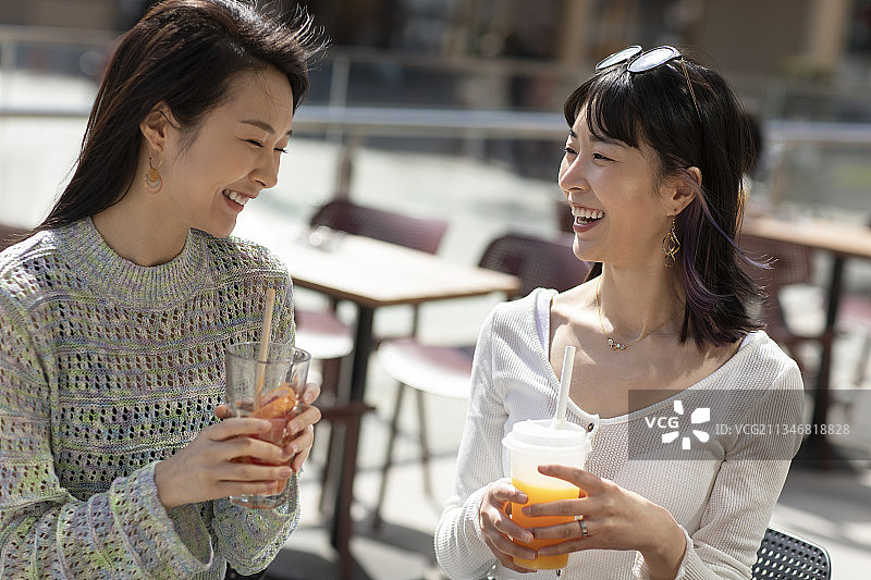 闺蜜俩在露天咖啡馆聊天图片素材