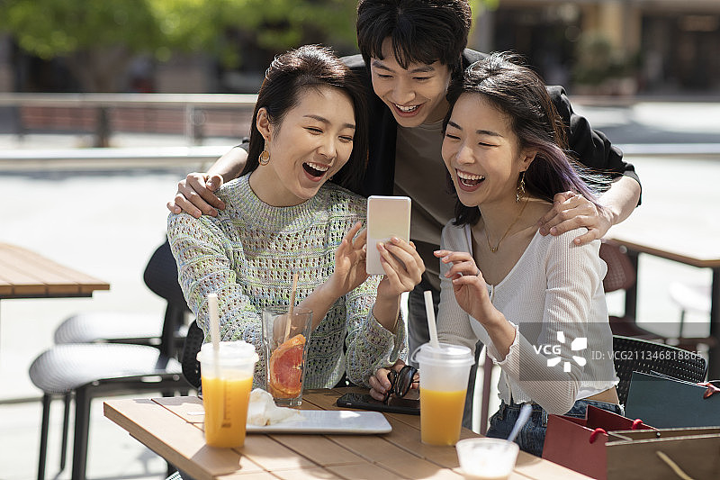 快乐的年轻人在露天咖啡馆聊天图片素材