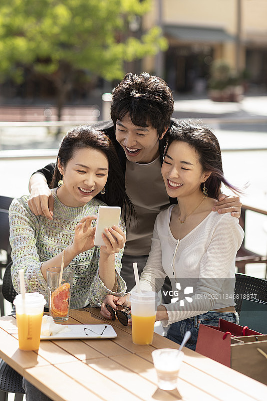 快乐的年轻人在露天咖啡馆聊天图片素材