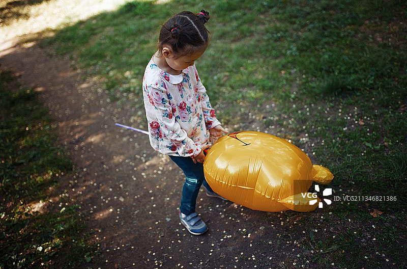 梳着发髻玩氦气球的女孩图片素材
