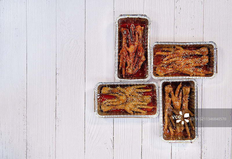 装在锡纸盒和盘子里的鸡爪图片素材