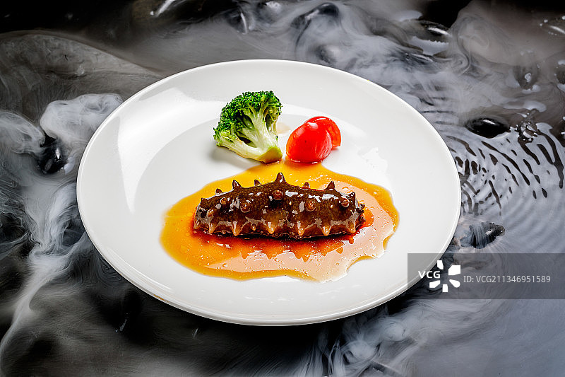 鲍汁扣辽参摆放在干冰缭绕的水中图片素材