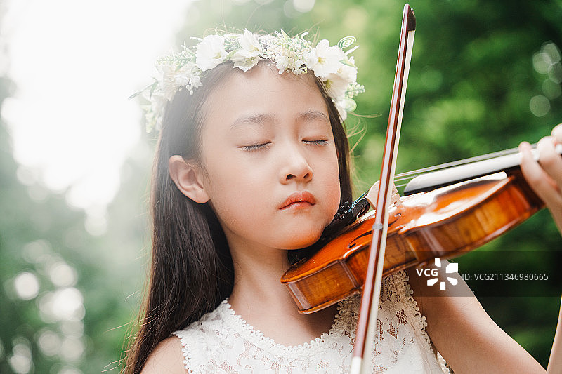 小女孩在公园演奏小提琴图片素材