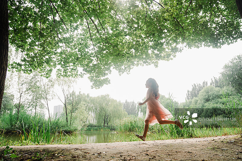 美丽的女孩在公园奔跑图片素材