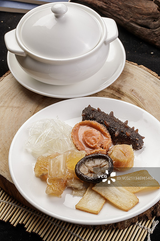 樟木砧板上的海鲜佛跳墙摆放在寿司帘上图片素材