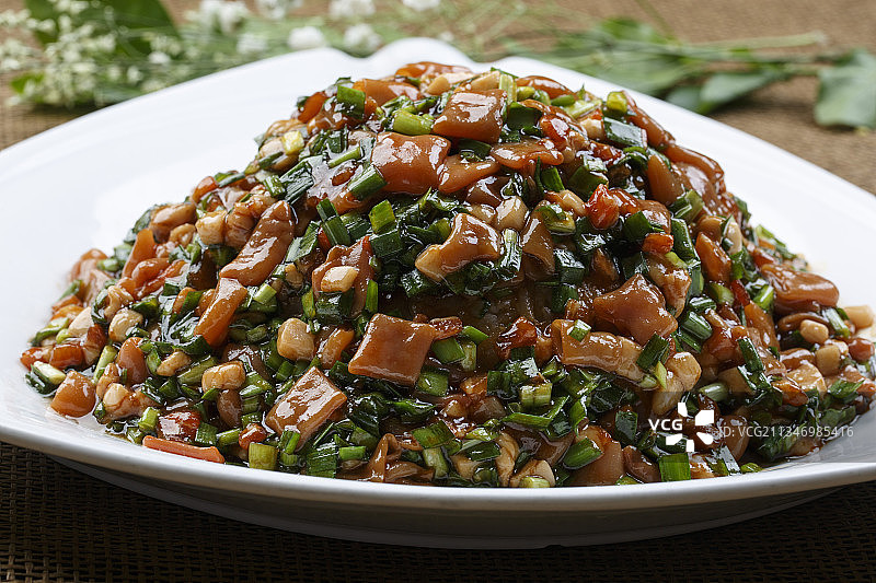 三角形白瓷盘装的韭菜炒海肠图片素材