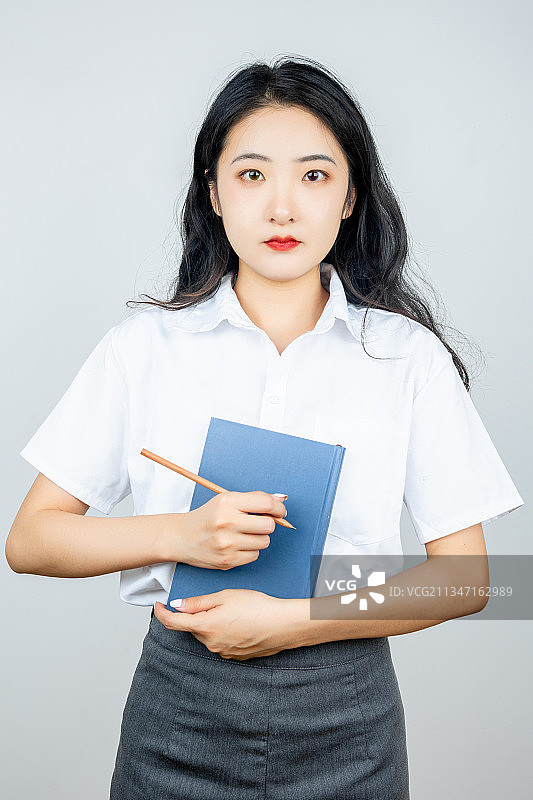 亚洲青年女性教师拿着书本备课图片素材