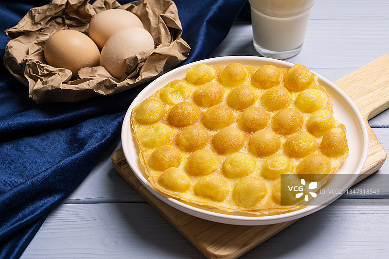 白色木板上的港式小吃原味鸡蛋仔图片素材