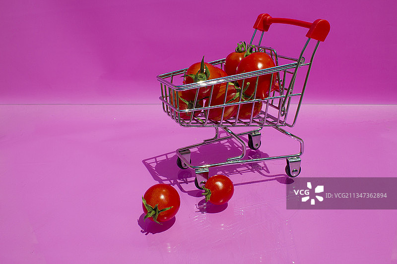 粉色背景上的购物车特写图片素材