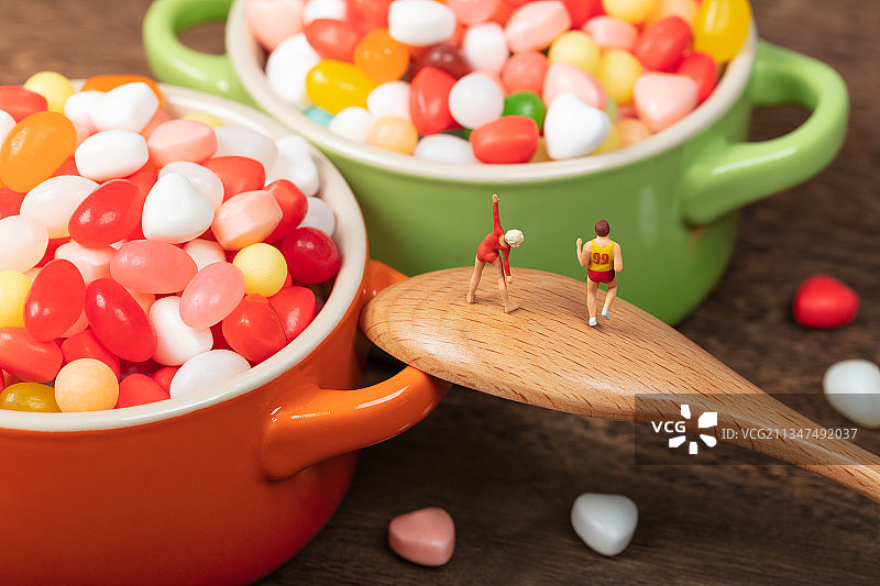 微缩创意木桌上的糖果碗与木勺子上运动减肥的男女图片素材