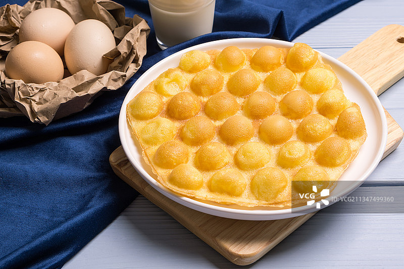 木板上的港式原味鸡蛋仔美食小吃图片素材
