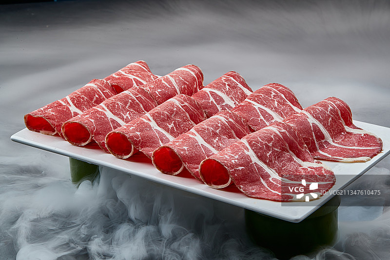 干冰缭绕的背景上摆放的高级雪花肥牛切片图片素材