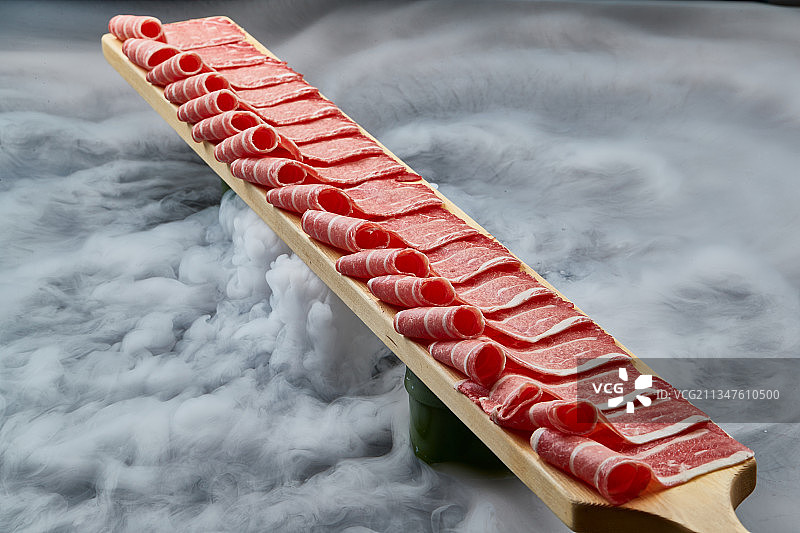 干冰缭绕的背景上摆放的和牛一米肉片图片素材