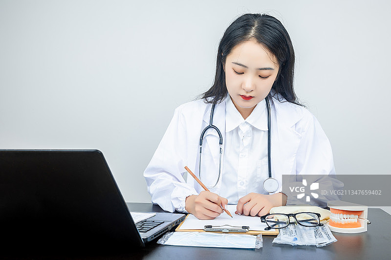 亚洲青年女性医生在电脑前专心工作图片素材