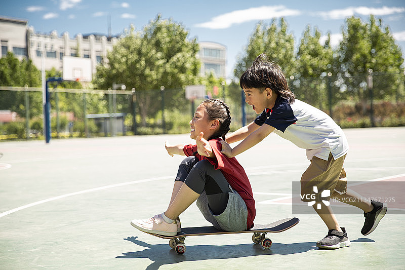 两个孩子户外玩滑板运动图片素材