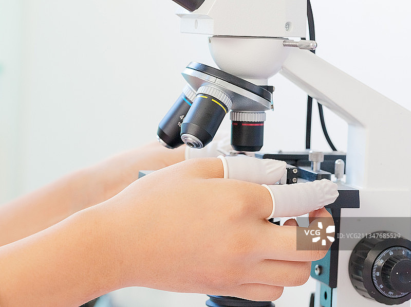 一个科学家正在用显微镜观察病毒图片素材