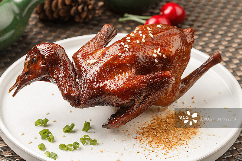 圆形白瓷盘装的港式脆皮乳鸽摆放在餐垫上图片素材