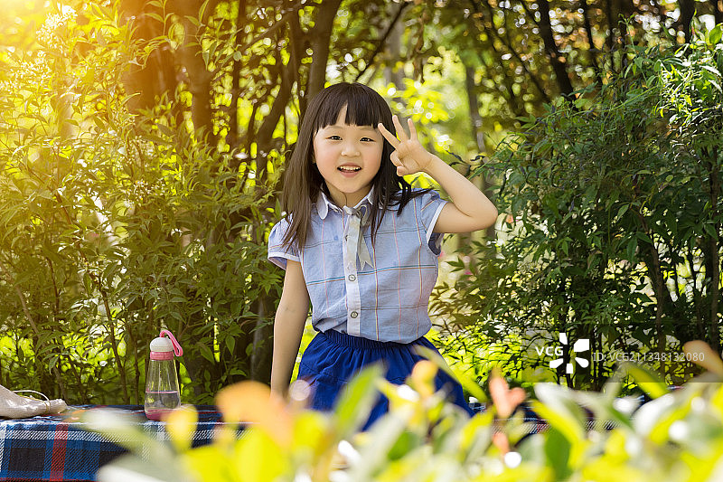坐在公园里做ok手势的孩子图片素材