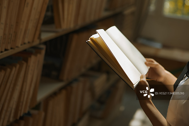 图书馆学生手里拿着书图片素材