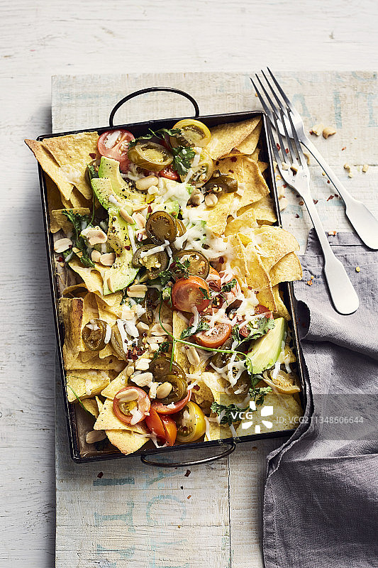 配山羊奶酪、鳄梨、墨西哥辣椒、番茄、香菜和花生酱的玉米片图片素材