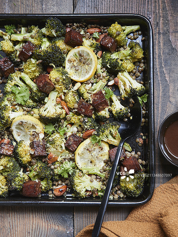 烤杏仁西兰花和绿扁豆床上的腌制天贝图片素材