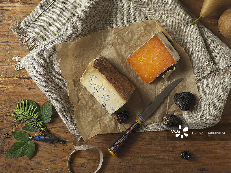 两块陈年奶酪和梨，在带刀的木质表面上图片素材