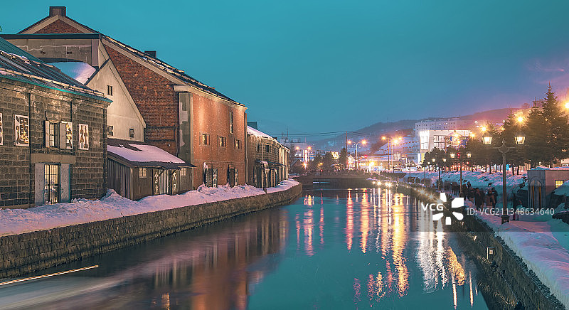 日本冬季旅行，北海道小樽，雪天的运河与城市街道图片素材