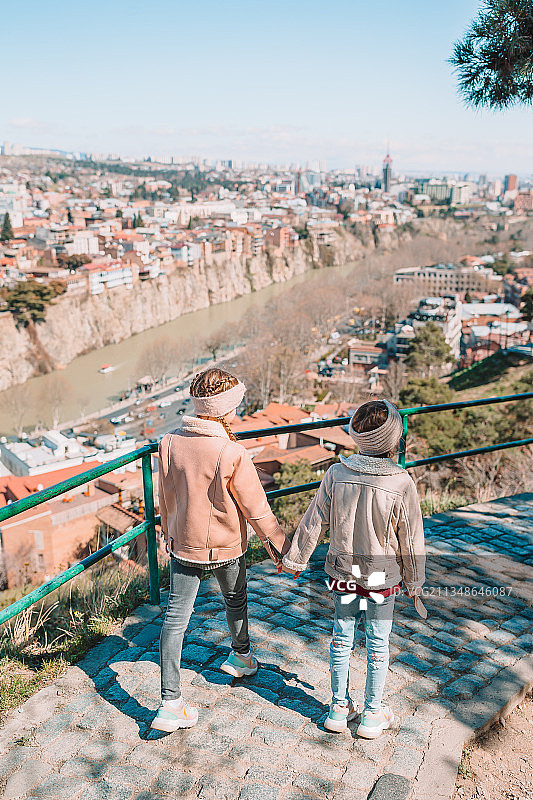 姐妹在城市景观的道路上行走的背影图片素材