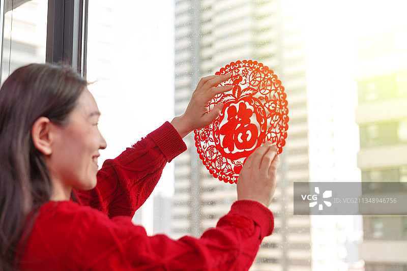 过年在家贴福字的女人图片素材