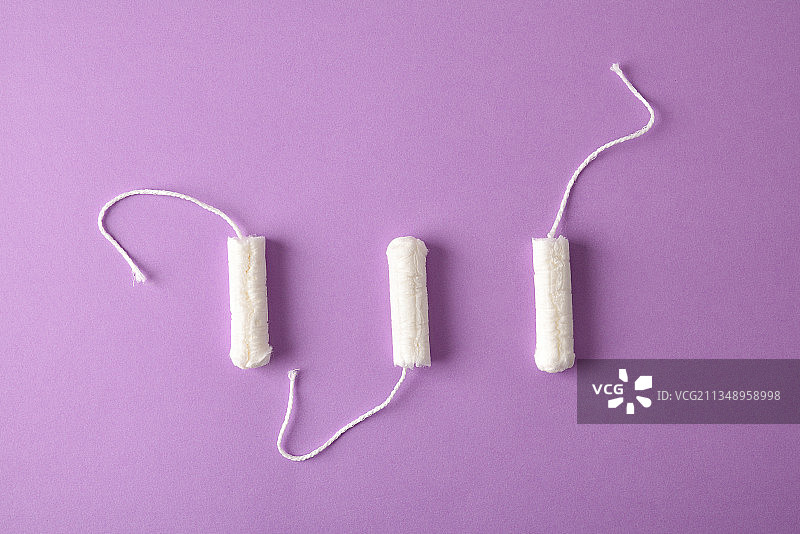 丁香色背景上的三支女性护理用卫生棉条图片素材
