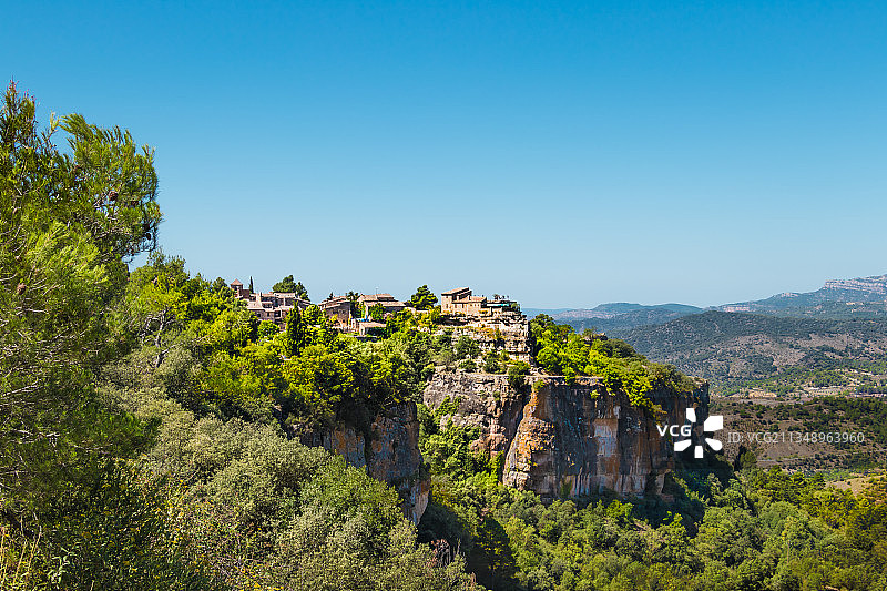 西班牙塔拉戈纳锡乌拉纳的蓝天下，山上的树木和植物图片素材