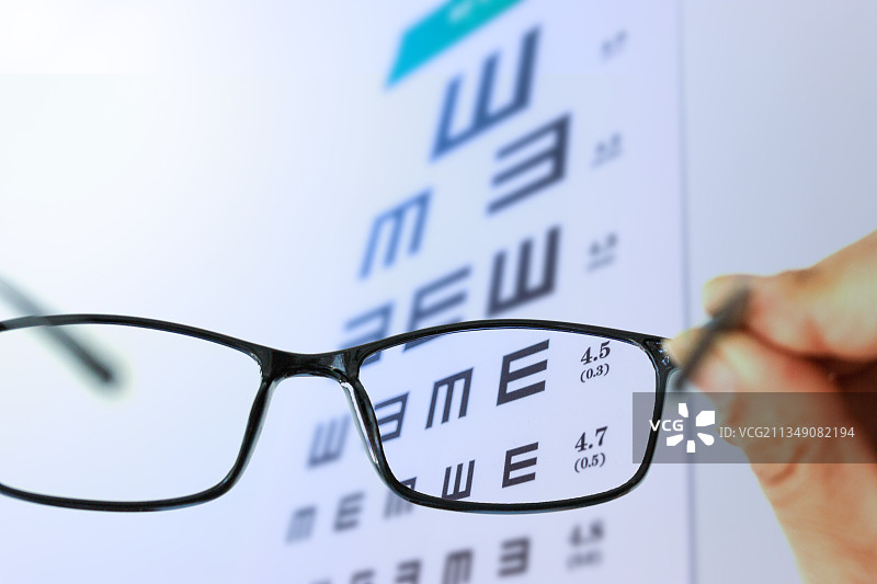 手拿眼镜看视力表图片素材