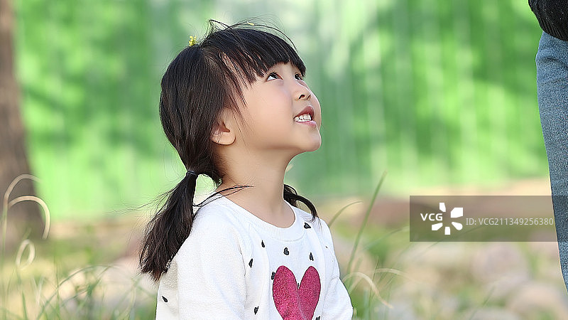 户外抬头看的小女孩图片素材