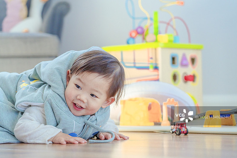 幼儿小精灵在玩具屋开心地趴在地板上图片素材