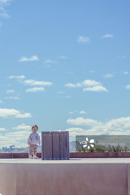 蓝天下山顶处停留的快乐男孩图片素材