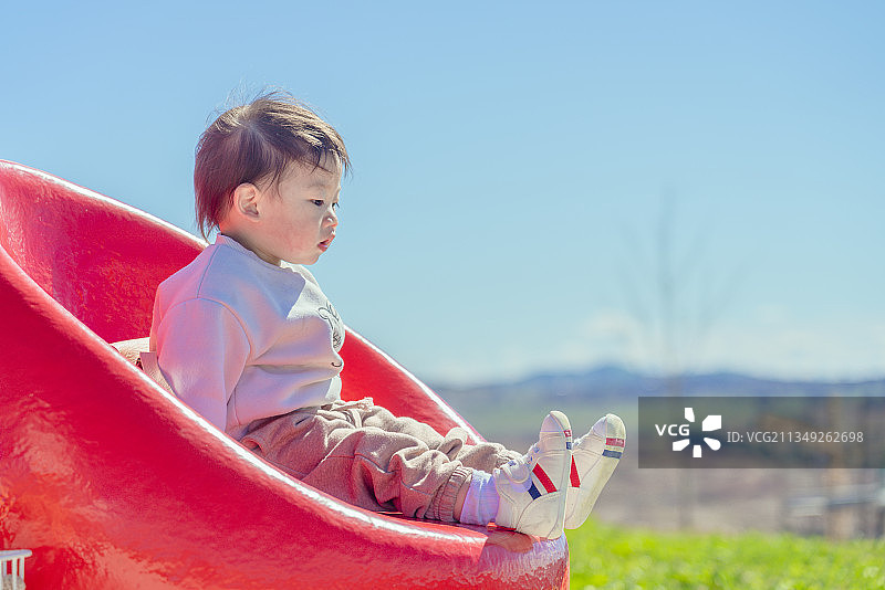 乐园橙色球体座椅上的小男孩图片素材