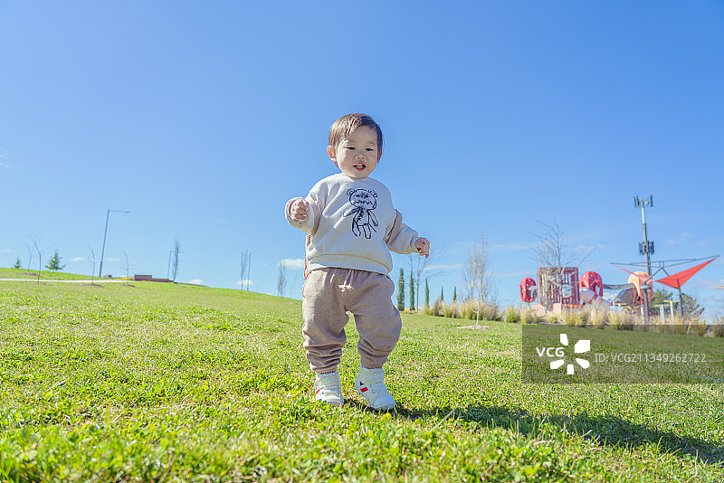 游乐园外草坪上的男孩图片素材