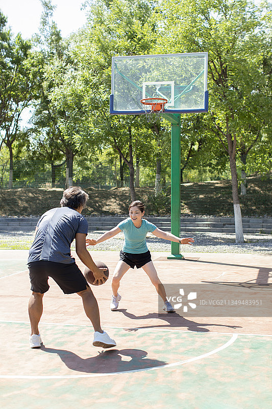 开心的中老年夫妇在篮球场打篮球图片素材