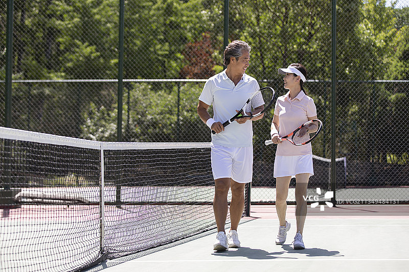 开心的中老年夫妇在网球场打网球图片素材