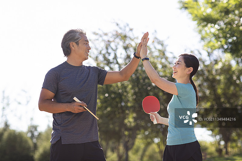 开心的中老年夫妇在户外打乒乓球图片素材
