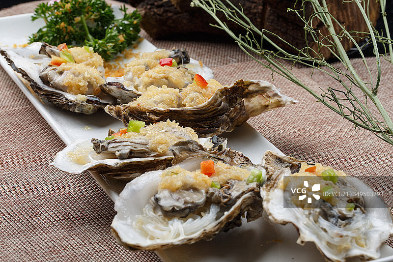 条形白瓷盘装的蒜蓉粉丝蒸生蚝图片素材