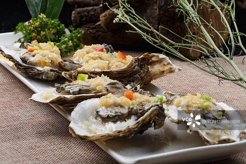 条形白瓷盘装的蒜蓉粉丝蒸生蚝图片素材