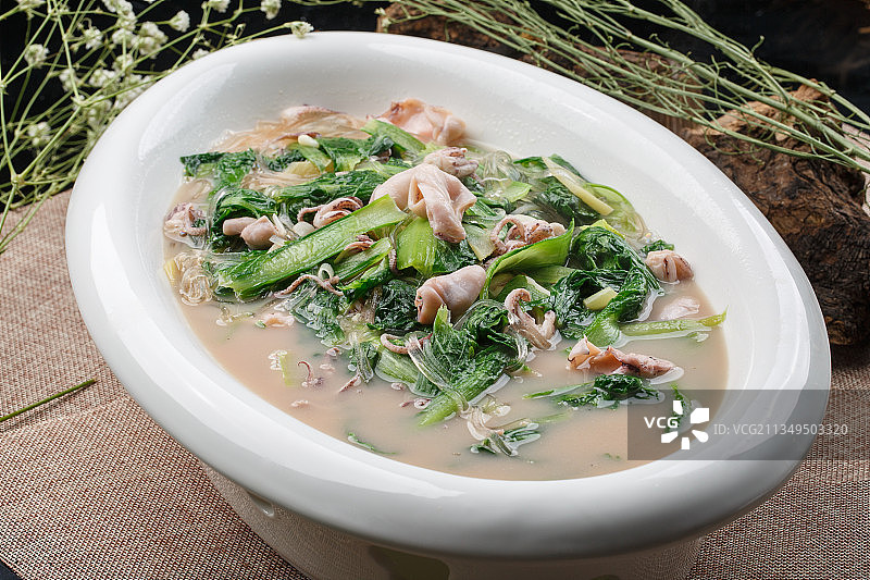 椭圆白瓷盘装的海鲜小白菜烩海兔图片素材