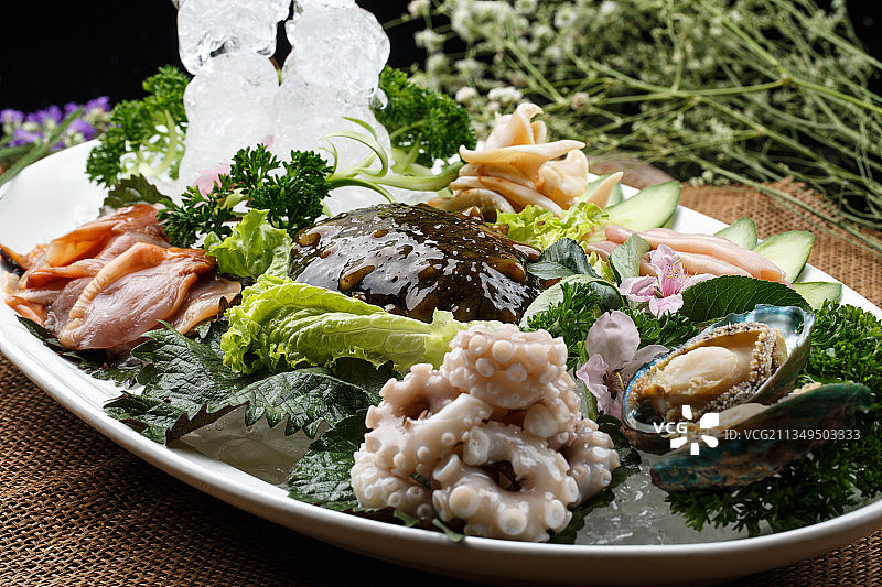 椭圆形白瓷盘装的胶东海鲜刺身拼盘图片素材