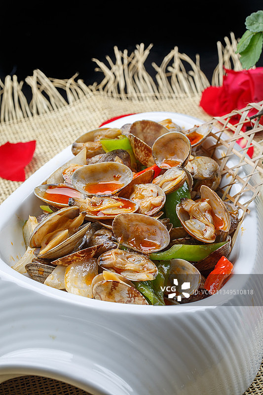 异形白瓷盘装的海鲜辣炒花蛤图片素材